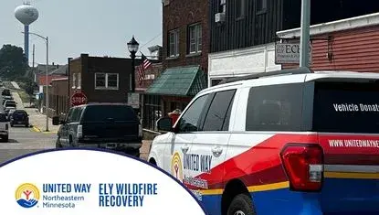 United Way of NE MN on Ely street - in foreground, in a white circle, text reads Ely Wildfire Recovery